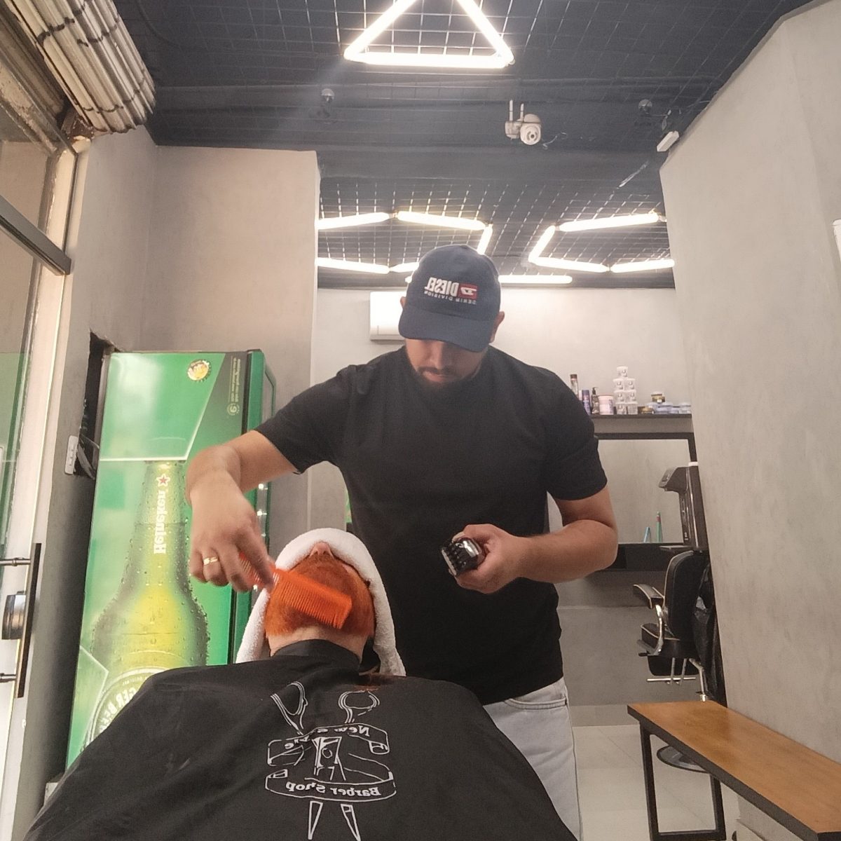 Aurelio fazendo barba com toalha quente em cliente na New Style